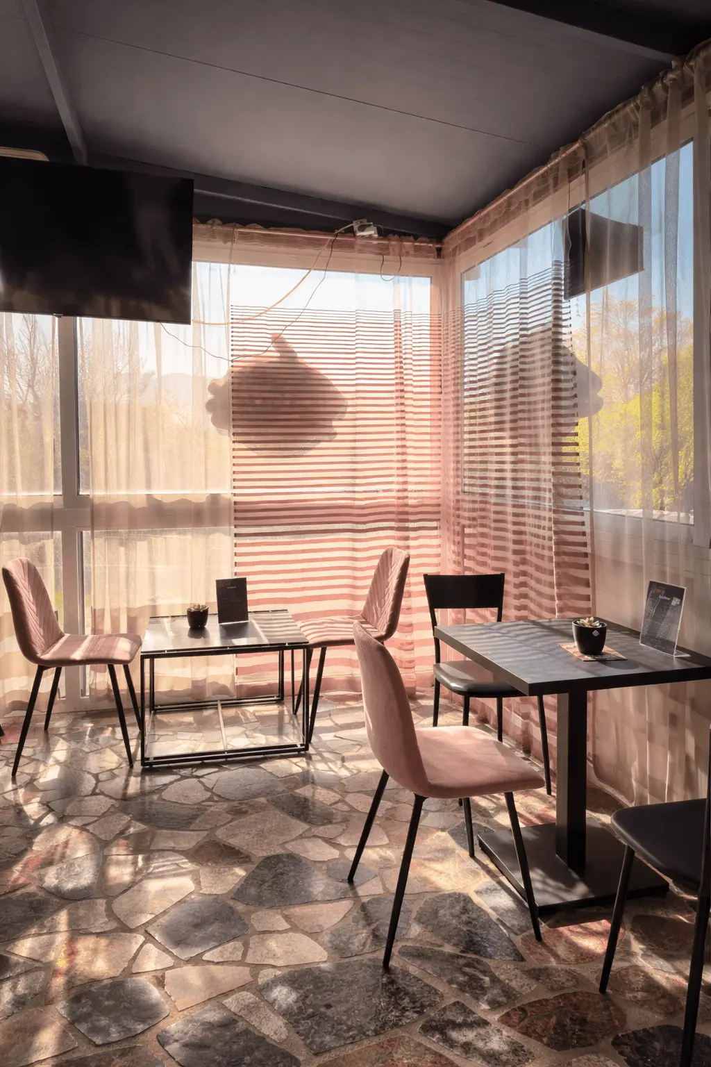 Sunlit café with pink velvet chairs